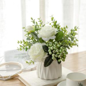 un vase blanc rempli de fleurs blanches sur une table dans l'établissement Vicoletto Fiorito, à Porto Empedocle