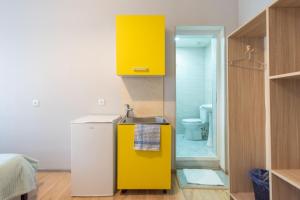 Cette chambre comprend un réfrigérateur jaune et une salle de bains. dans l'établissement Apartment Panorama, à Tbilissi