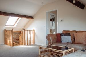 a living room with a couch and a staircase at Family Getaway at Working Farm in Church Fenton