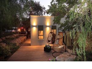 una pequeña casa en una terraza de madera en un patio en Oak Shade en Bet Leẖem HaGelilit