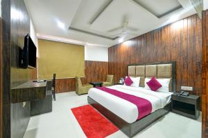 1 dormitorio con 1 cama grande con alfombra roja en Hotel Seven Inns Qubic Near Delhi Airport, en Nueva Delhi