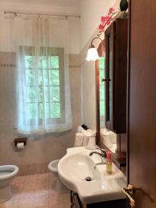La salle de bains est pourvue d'un lavabo, de toilettes et d'une fenêtre. dans l'établissement Casa vacanze Bonardini, à Castiglione del Lago