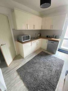 a kitchen with white cabinets and a rug at Spacious Ashley Cross Flat in Parkstone
