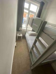 ein kleines Zimmer mit einem Etagenbett und einem Fenster in der Unterkunft Spacious Ashley Cross Flat in Parkstone