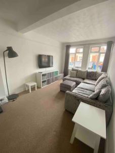a living room with a couch and a tv at Spacious Ashley Cross Flat in Parkstone