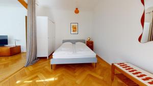 - une chambre avec un lit blanc et du parquet dans l'établissement Unique Serviced Living @ Wettstein Turnerstrasse, à Bâle