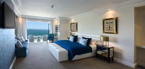 um quarto com uma cama e um sofá em The Clarendon - Bantry Bay em Cidade do Cabo