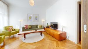 - un salon avec un canapé et une télévision dans l'établissement Unique Serviced Living @ Wettstein Turnerstrasse, à Bâle