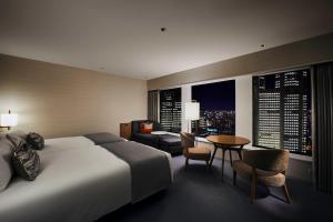 a hotel room with a bed and a table and chairs at Keio Plaza Hotel Tokyo in Tokyo