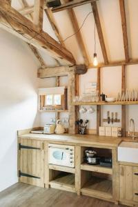 a kitchen with wooden cabinets and a counter top at 5 Henham Barns in Beccles