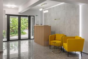 a waiting room with two yellow chairs and a table at Otopeni Suites by CityBookings in Otopeni