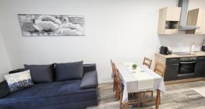 uma sala de estar com um sofá, uma mesa e uma cozinha em Juhar 1 Apartman em Kőszeg