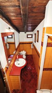 baño con lavabo rojo y aseo en Ruggero House, en Cefalú