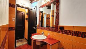 y baño con lavabo y espejo. en Ruggero House, en Cefalú