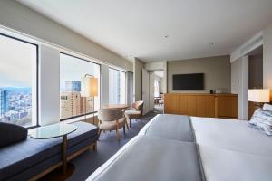 a hotel room with a large bed and a couch at Keio Plaza Hotel Tokyo in Tokyo