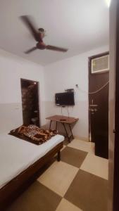 新德里的住宿－BANSAL INN Near Aiims Hospital，客房设有一张床和一个吊扇。
