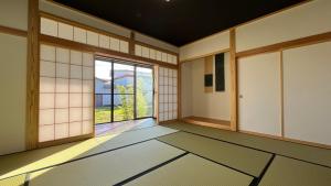 an empty room with a large window and a door at ミロクハウス in Daisen