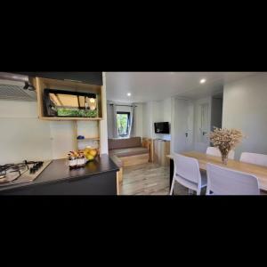 une cuisine avec un comptoir et une table avec des chaises dans l'établissement Mobil Home Premium 3 ch Camping 5 Biscarrosse Mayotte F64, à Biscarrosse