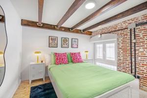 Un dormitorio con una cama verde y una pared de ladrillo en Aesthetic Apt, 15min Gran Vía, Sol, Theme park en Madrid