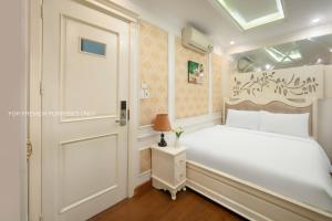 Postel nebo postele na pokoji v ubytování The Silk Grand Premium Hotel & Spa - In Hanoi Old Quarter