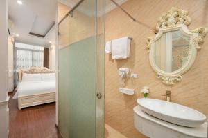 ein Badezimmer mit einem WC, einem Waschbecken und einem Spiegel in der Unterkunft The Silk Grand Premium Hotel & Spa in Hanoi