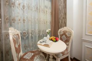 ein Badezimmer mit einem Tisch, 2 Stühlen und einem Waschbecken in der Unterkunft The Silk Grand Premium Hotel & Spa in Hanoi