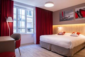 圣马洛Hôtel des Marins, Saint-Malo的酒店客房,设有一张带红色窗帘的大床