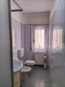 a bathroom with two toilets and a sink and a window at [Casa Tizzy] Frontemare in Borghetto Santo Spirito