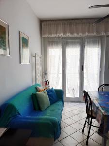 a living room with a green couch and a table at [Casa Tizzy] Frontemare in Borghetto Santo Spirito