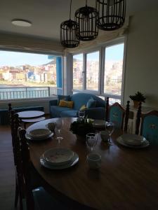 a dining room table with plates and wine glasses at Vacacional muelle alto A Guarda in A Guarda