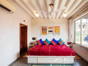 a bedroom with a red bed with blue pillows at Mangaldas Ni Haveli II by The House of MG in Ahmedabad