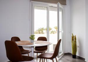 a dining room with a table and chairs and a window at Gaviotas Golf Beach in Almerimar