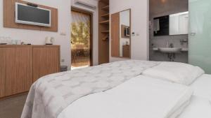 1 dormitorio con cama blanca y lavamanos en Villa Lučica Trogir, en Trogir