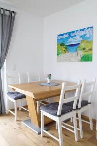 mesa de comedor y sillas con una pintura en la pared en Appartement HANNE, en Saalfelden am Steinernen Meer