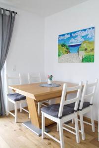 a dining room table and chairs with a painting on the wall at Appartement HANNE in Saalfelden am Steinernen Meer