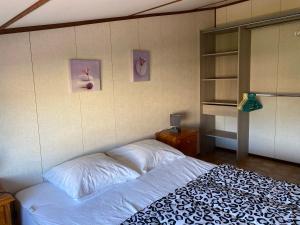a bed in a bedroom with two pictures on the wall at Portiragnes-Plage - Les Portes du Soleil - Maison 75m² - A2 in Portiragnes