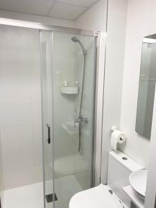 een witte badkamer met een douche en een toilet bij Alojamiento Amelie con WiFi gratis in Murcia