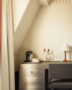 une chambre avec une table avec une lampe et un rideau dans l'établissement Hôtel Des Grands Voyageurs, à Paris