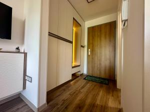 um quarto com um corredor com uma porta e pisos em madeira em Rabbit 2 Apartman em Mosonmagyaróvár