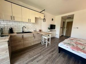 uma cozinha com uma mesa e uma cama num quarto em Rabbit 2 Apartman em Mosonmagyaróvár