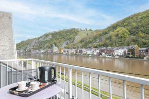 een koffiezetapparaat op een tafel op een balkon met uitzicht op een rivier bij Les Gites Kangourou Dinant in Dinant