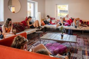 eine Gruppe von Personen, die auf Sofas in einem Raum sitzen in der Unterkunft Wombat's City Hostel Munich Werksviertel in München