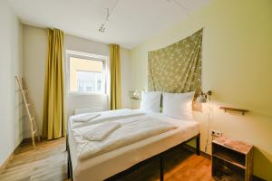 a bedroom with a large bed with a window at Wombat's City Hostel Munich Werksviertel in Munich