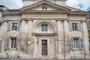 アヴィニョンにあるLa Chapelle du Miracleの窓とドアのある大きな石造りの建物