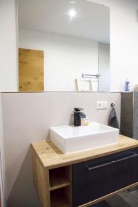 a bathroom with a white sink and a mirror at Appartement HANNE in Saalfelden am Steinernen Meer