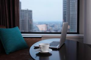 a laptop computer sitting on a table with a cup of coffee at Keio Plaza Hotel Tokyo in Tokyo