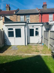 a white garage with two doors in front of a house at City Dreams in Croydon