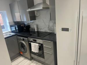 uma cozinha com um fogão e uma máquina de lavar roupa em HOMESTAY HAVEN em Leicester