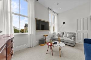 a living room with a couch and a tv at Pelican Suite - Design 1Bed Flat in Harrogate