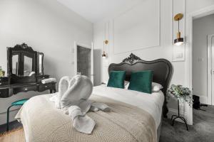 a bedroom with a bed with a towel animal on it at Pelican Suite - Design 1Bed Flat in Harrogate
